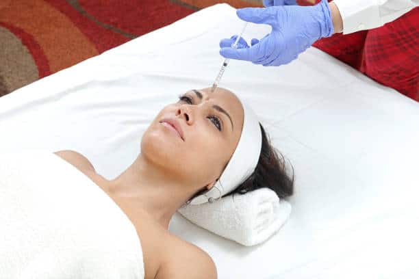 Woman Having Forehead Injection Filler Treatment at Beauty Clinic